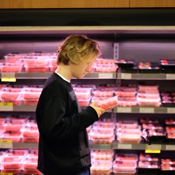 Jeune homme dans un rayon de supermarché.